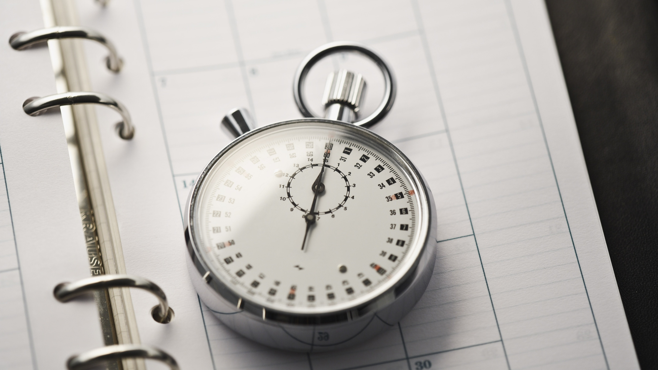 five-minute-google-business-profile-audit-timer Stopwatch resting on a calendar page, representing the five-minute Google Business Profile audit