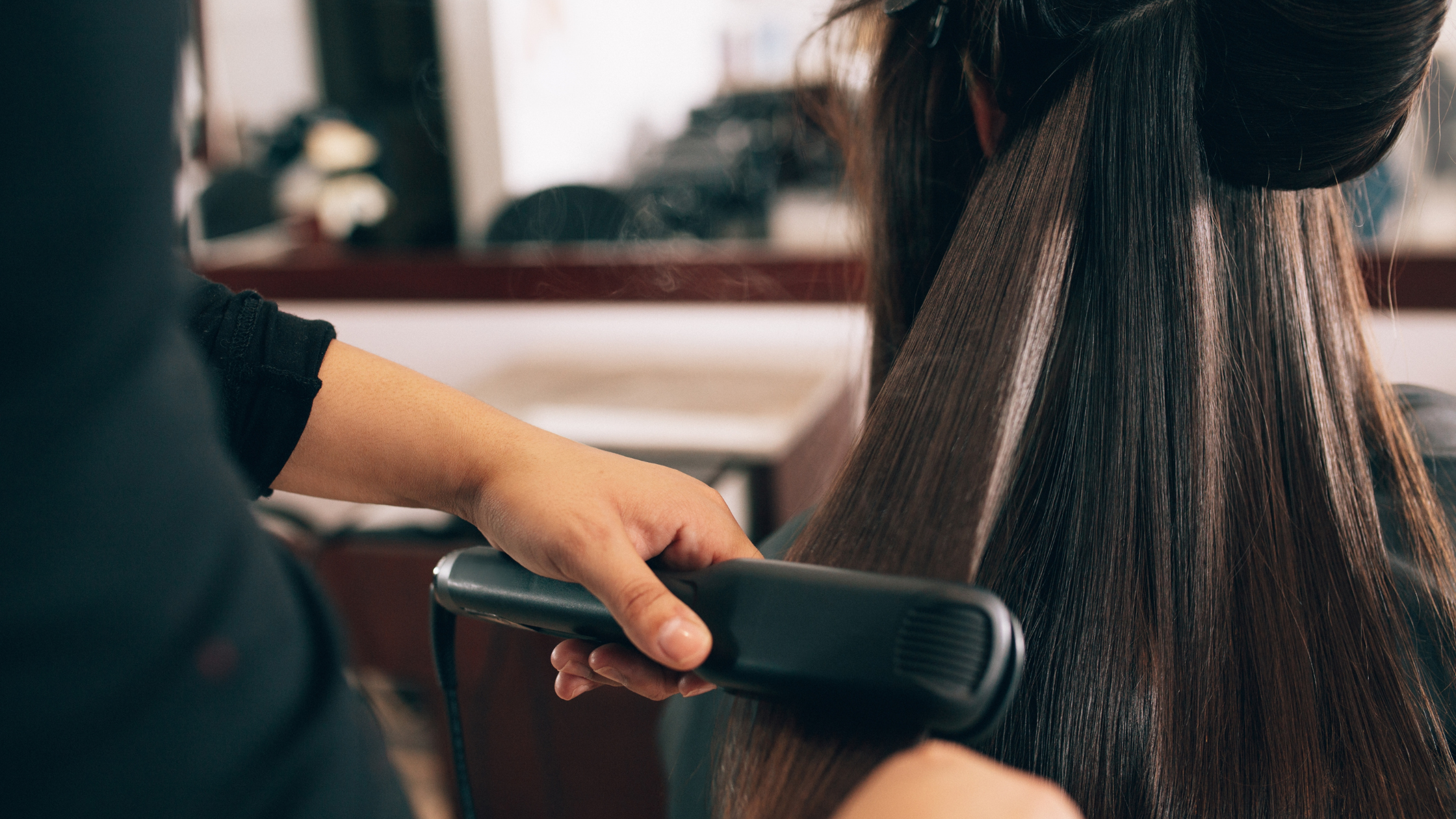 Stylist straightening a client's hair at a Rantoul salon, the kind of service business AI automation frees up staff time for